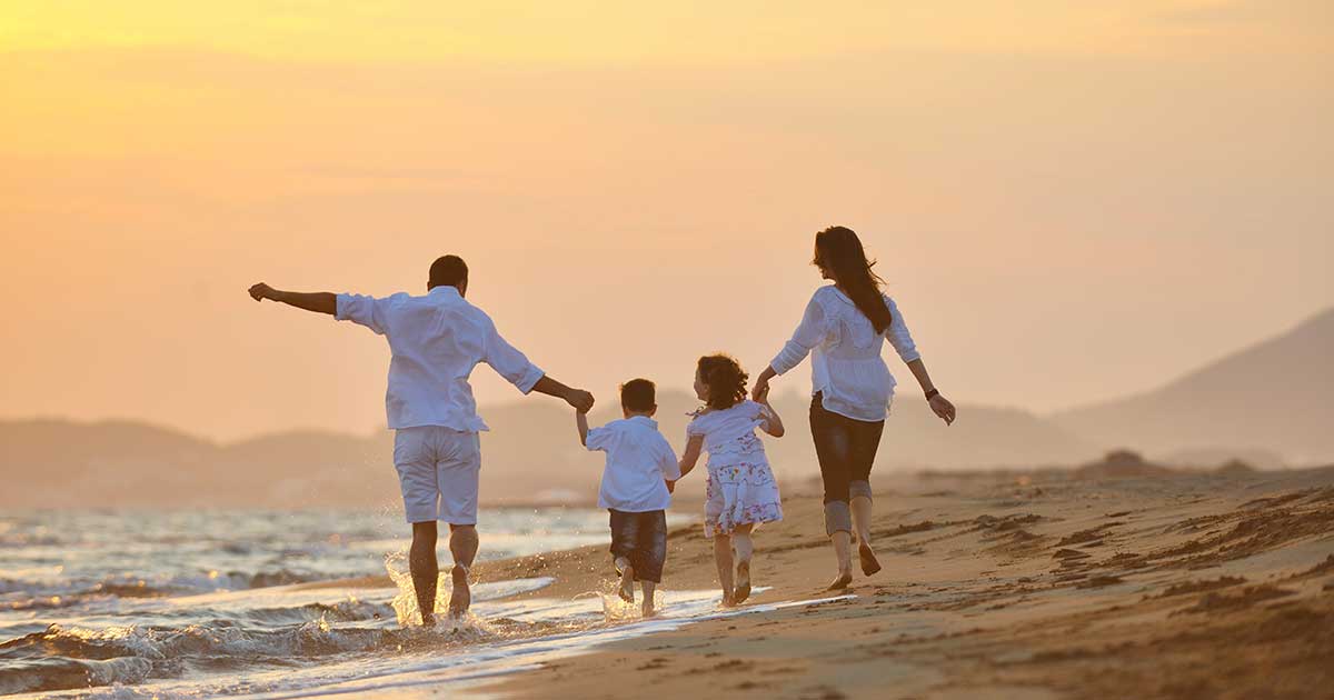 Family walking on the beach | One-Stop Financial Advice